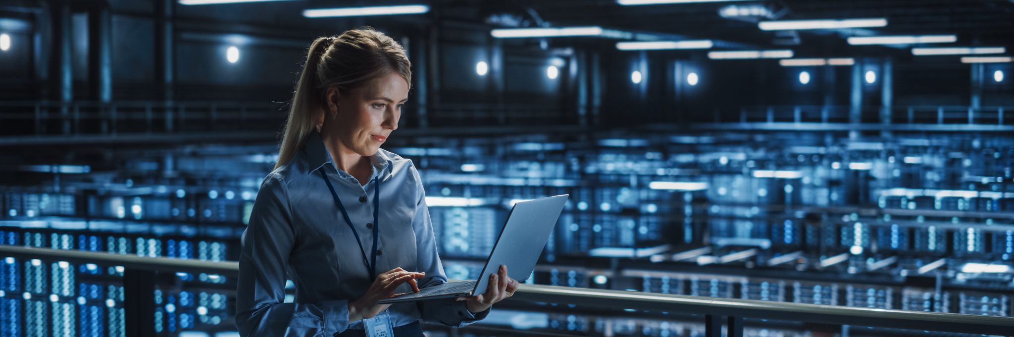 Data Center Female It Specialist Using Laptop. Server Farm Cloud Computing and Cyber Security Maintenance Administrator Working on Computer. Information Technology Professional.